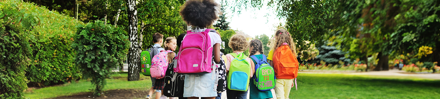 happy children running off to school with their backpacks.