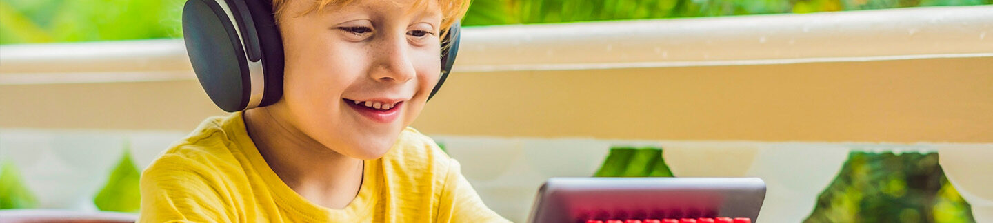 A young boy using augmentative and alternative communication on his tablet.