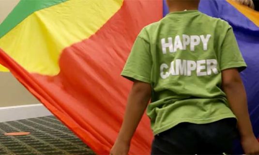 Camper playing a game and wearing a shirt that reads, 