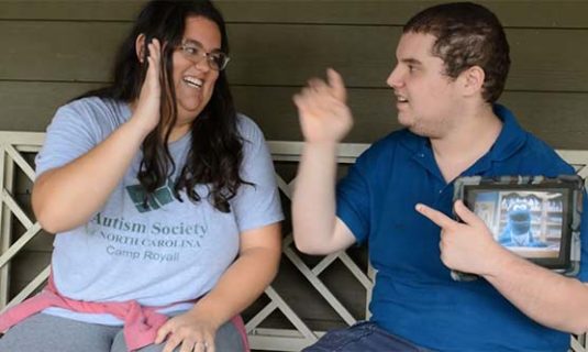 A camp counselor and camper high-fiving.