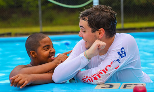 Camper and Counselor smiling in the pool