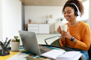 An autistic adult who is enjoying coffee while working after disclosing disability in the workplace