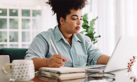 A woman attending an autism webinar on a laptop.