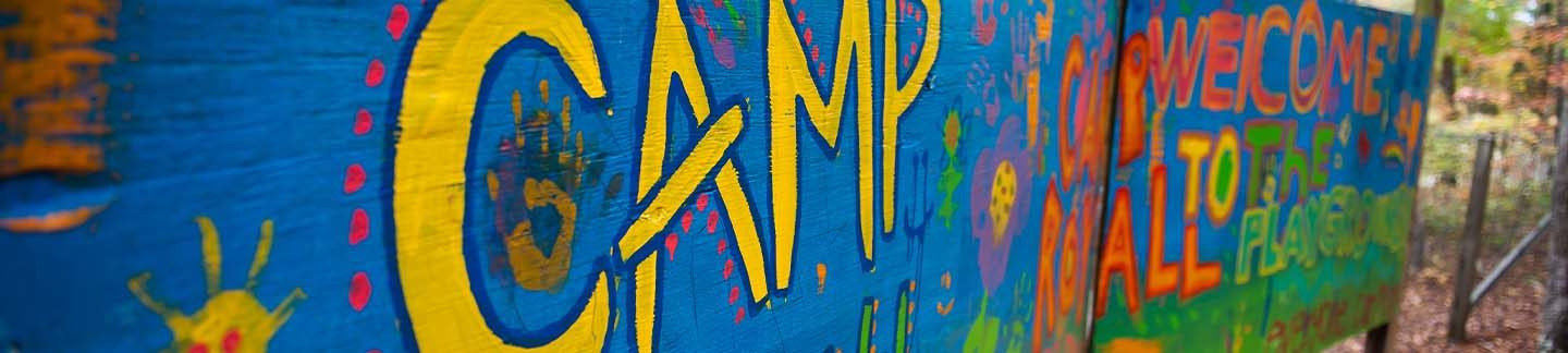 A colorful painted sign, welcoming campers to Campo Royall