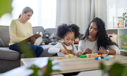 A child is being assessed by a therapist during her early years.