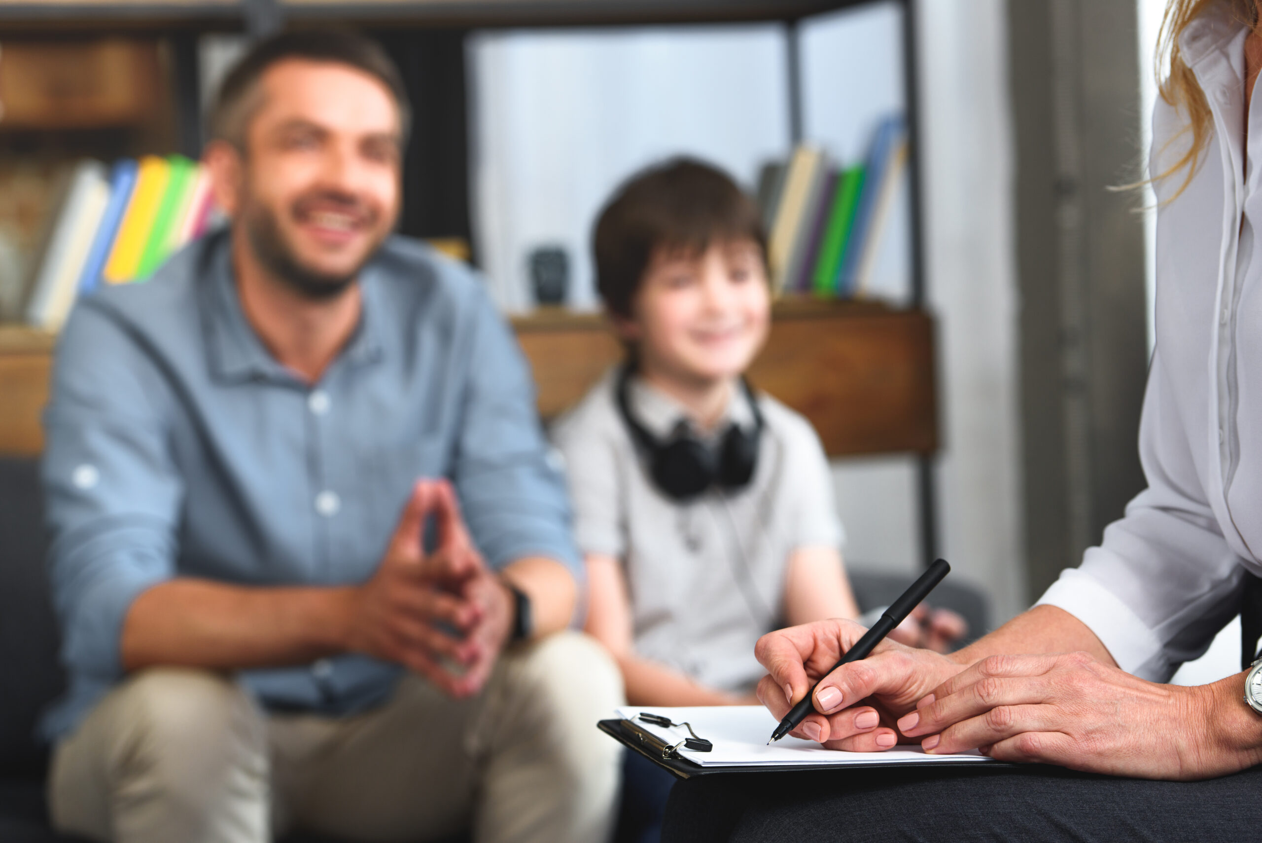 A father and son speaking with a family therapist.