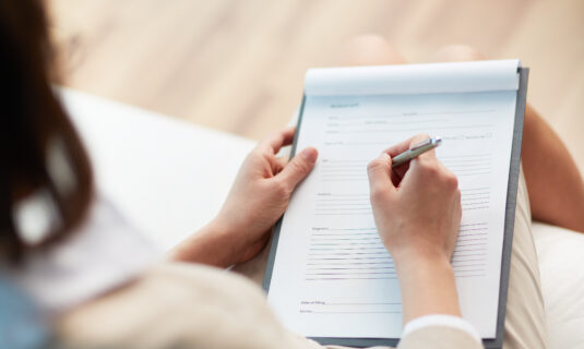 Therapist taking notes for a patient pursuing a diagnosis for autism.