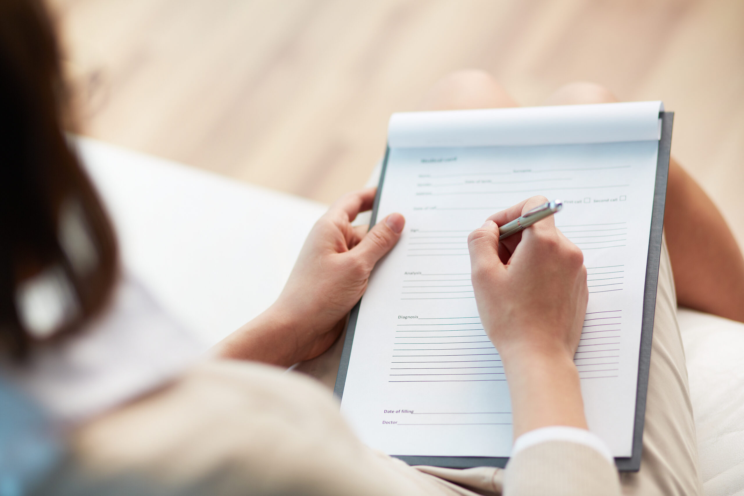 Medical record Therapist taking notes for a patient pursuing a diagnosis for autism.